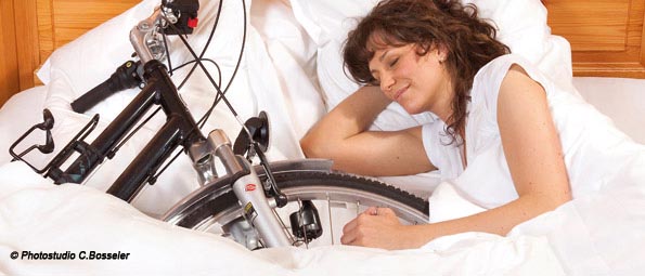 Femme dormant dans un lit avec son vélo